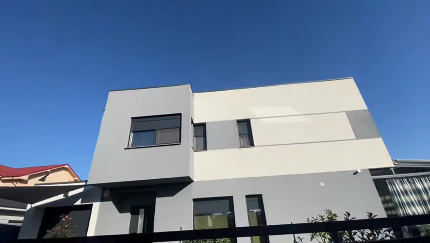 Casă cu fațadă albă, volume gri și ferestre antracit