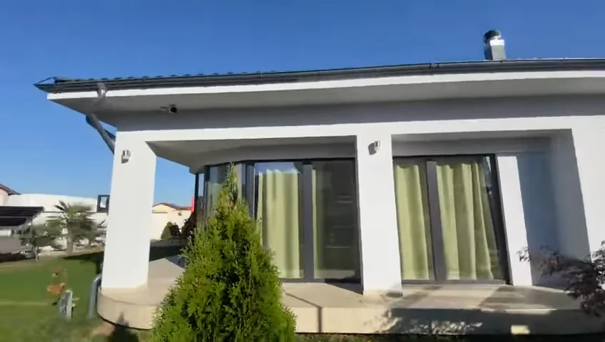 Terasă acoperită lângă gazon și conifere